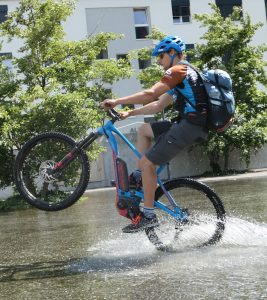 beitune Guide André fährt mit dem E-MTB Wheelie.