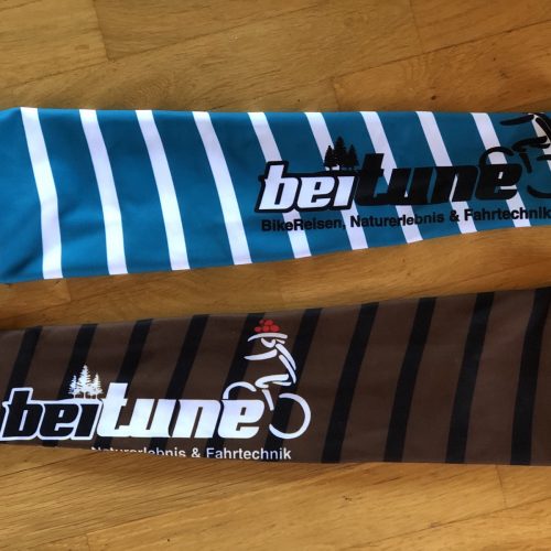 beitune Armlinge in braun und türkis mit Streifen und beitune Logo.