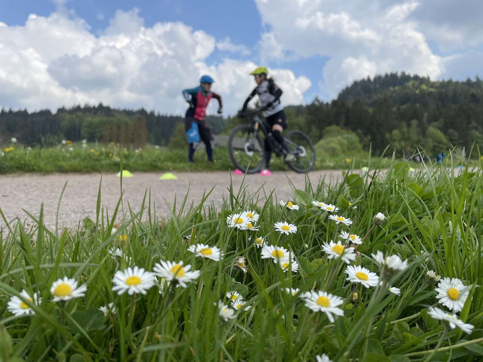 Zwei Mountainbikerinnen auf einer Blumenwiese beim beitune Frauen-Fahrtechniktraining.