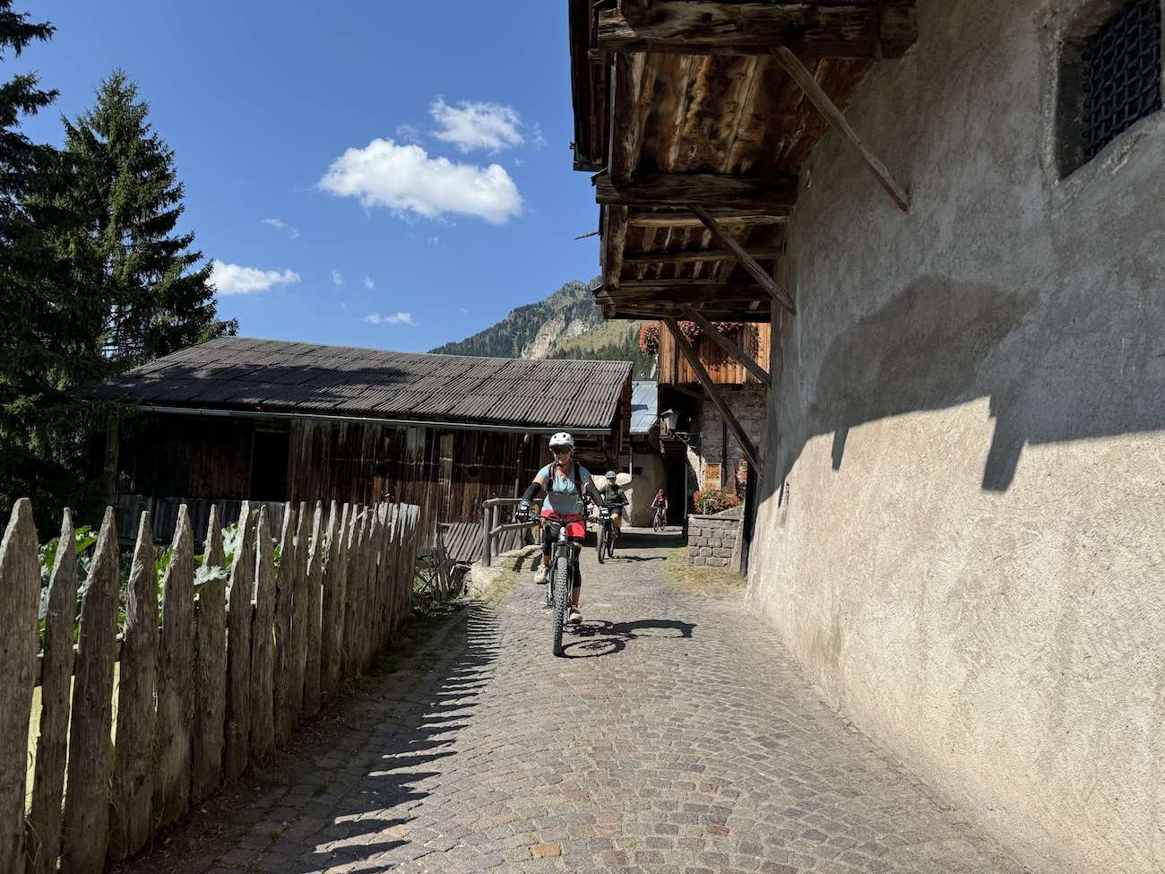 Mountainbikerin fährt bei der beitune Frauen-Transalp durch eine alte Ortschaft