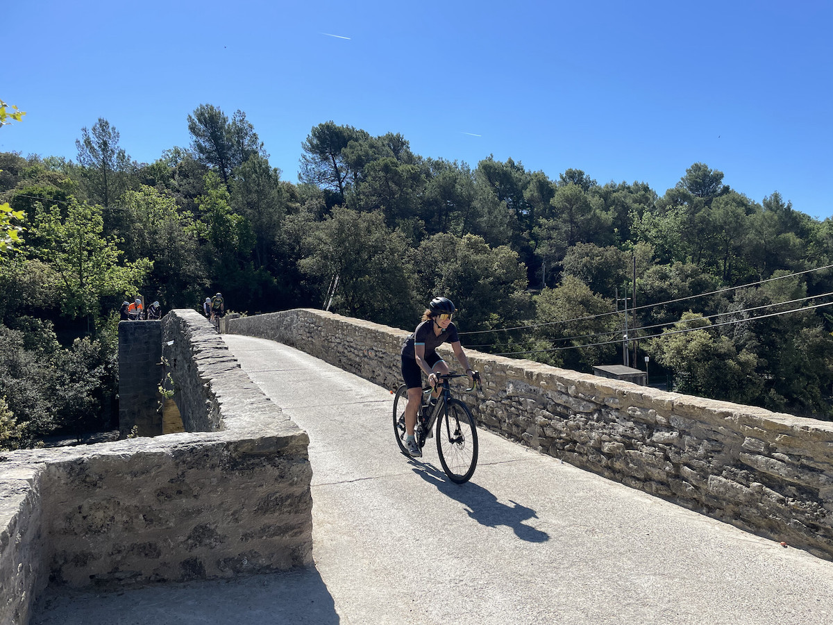 Rennradfahrerin fährt bei der beitune Rennrad-Woche am Mont Ventoux über eine Steinbrücke