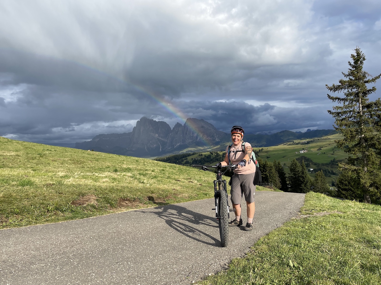 beitune Frauen-Transalp | Alpenüberquerung für Frauen: Mountainbikerin vor Regenbogen auf Seiser Alm