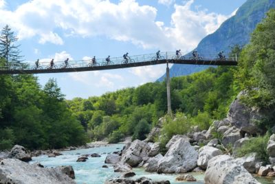 Mountainbiker fahren über Hängebrücke im Soca-Tal auf der beitune Trans-Slowenien.