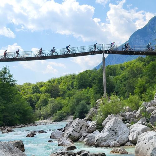 Mountainbiker fahren über eine Hängebrücke im Soca-Tal auf der beitune Trans-Slowenien.